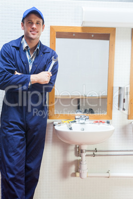 Happy plumber posing with wrench