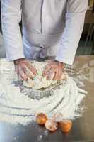 Close up of baker kneading dough