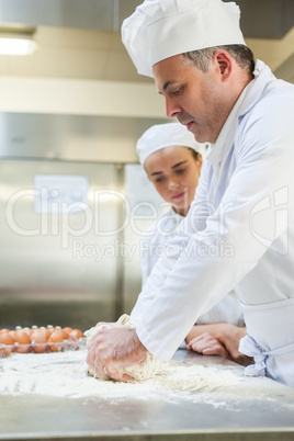 Focused head chef kneading dough