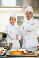 Frowning chef and head chef standing arms crossed