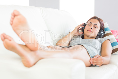 Young brunette woman listening to music with closed eyes