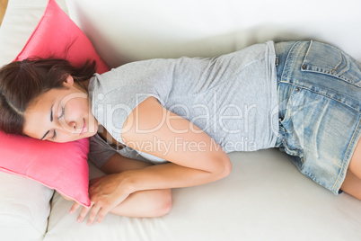Attractive young woman sleeping on her white couch