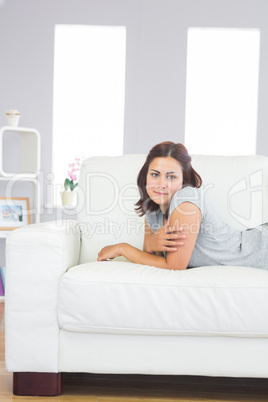 Attractive calm woman lying on a white couch