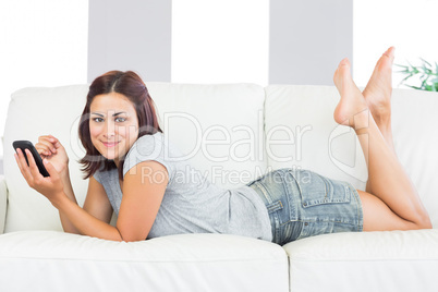 Content young woman lying on her couch at home