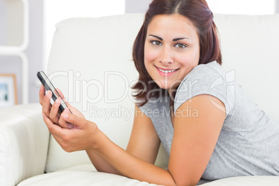 Portrait of young woman lying on her couch in the living room