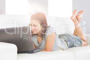 Content brunette woman lying on her white couch