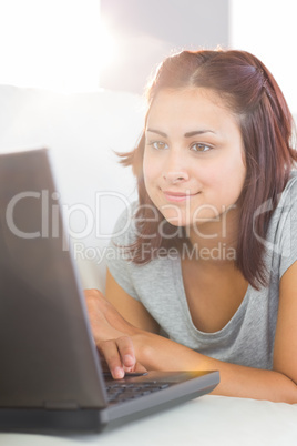 Content young woman making use of her notebook