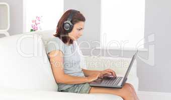 Concentrated casual woman working with her notebook while listen