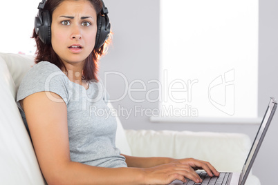 Surprised brunette woman working with her notebook and listening