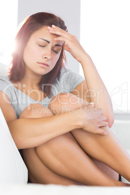 Upset beautiful woman sitting on her couch