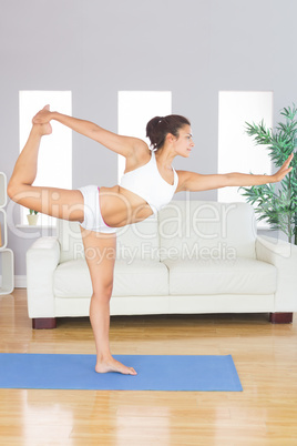 Concentrated slim woman stretching her body in yoga pose