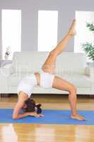 Profile view of slim woman practicing yoga pose on exercise mat
