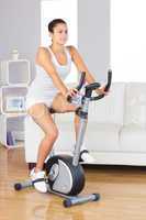 Young brunette woman training on an exercise bike