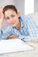 Portrait of calm young student doing assignments while lying on