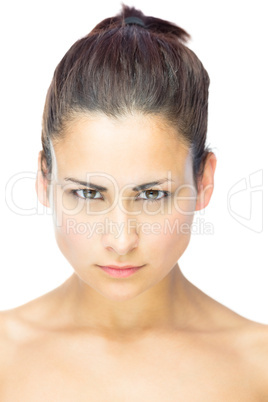Front view of focused young woman gazing at camera