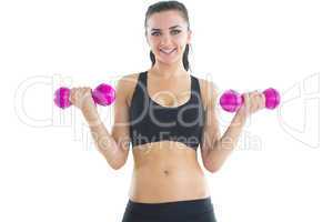 Peaceful active woman training her arms with pink dumbbells