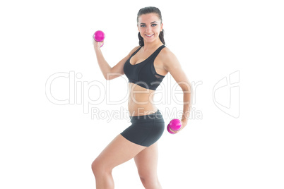 Pretty fit woman training with pink dumbbells