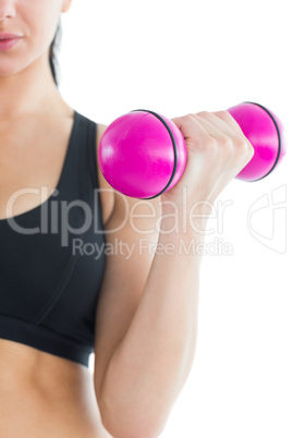 Mid section of slender active woman training her arm with a pink