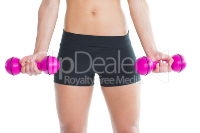 Close up of slender woman training with pink dumbbells