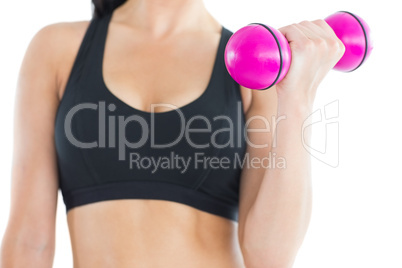 Close up of sporty young woman training with a pink dumbbell