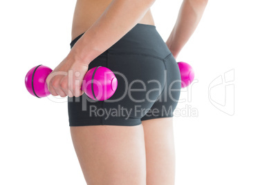 Close up of female bottom while training with pink dumbbells