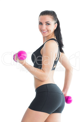 Portrait of smiling active woman training with pink dumbbells