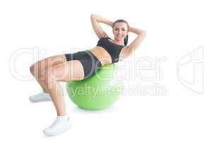 Joyful fit woman doing an exercise on an exercise ball