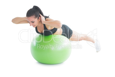Cute fit woman practicing an exercise on a fitness ball