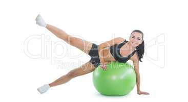 Content active woman doing an exercise on a green fitness ball