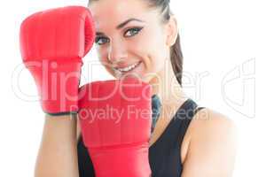 Attractive sporty woman smiling at camera wearing boxing gloves