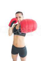 Attractive cheerful woman wearing red boxing gloves