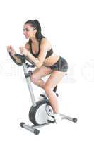 Pretty active woman training on an exercise bike
