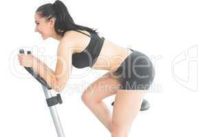 Joyful sporty woman training on an exercise bike
