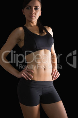 Sporty slender woman posing in sportswear with hands on hips
