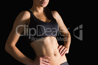 Mid section of slender sporty woman posing in sportswear