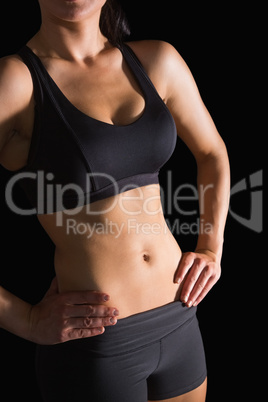 Mid section of slender fit woman posing in sportswear