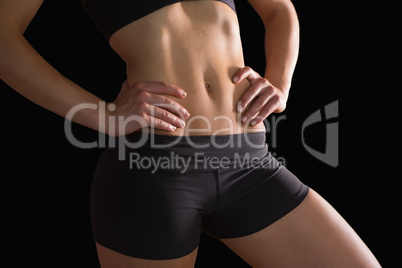 Mid section of slim fit woman posing in sportswear