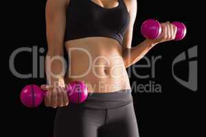 Slender active woman lifting pink dumbbells