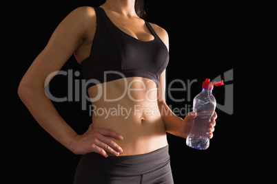 Mid section of slim woman holding a bottle of water