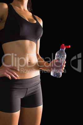 Mid section of attractive slim woman in sportswear holding a wat