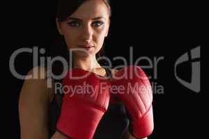 Beautiful sporty woman wearing boxing gloves looking at camera