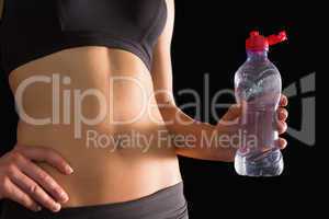 Close up of slim woman in sportswear holding a water bottle