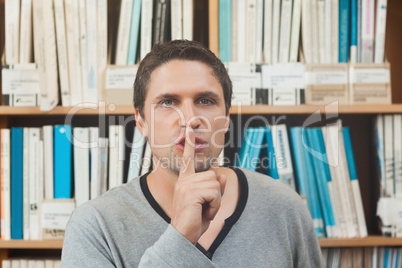 Brunette male librarian requesting silence in library