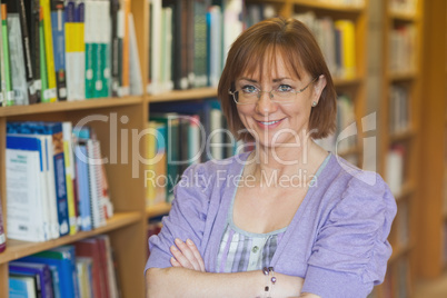 Mature intellectual woman posing in library