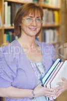 Female librarian posing holding some books