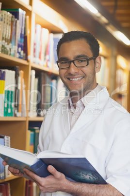 Intellectual handsome man posing holding an opened book in libra