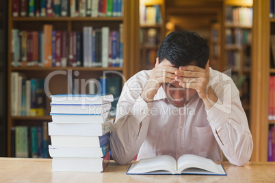 Young black haired man reading a book