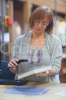 Mature female librarian scanning book