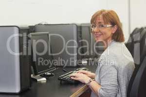 Smiling female mature student using a computer