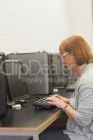 Focused mature student sitting in computer class